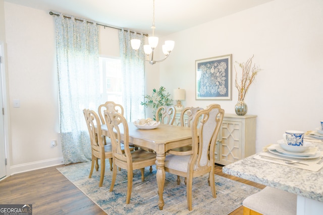 dining room with dark wood-type flooring and a notable chandelier