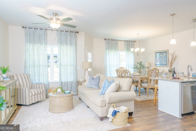 living room featuring sink, ceiling fan with notable chandelier, and hardwood / wood-style floors