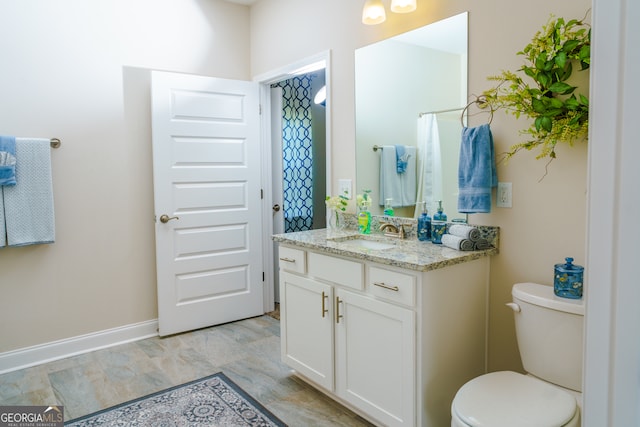 bathroom featuring tile patterned flooring, toilet, and vanity