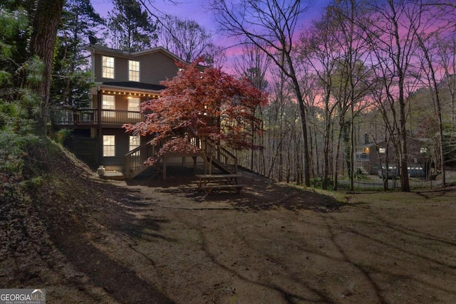 back house at dusk with a wooden deck