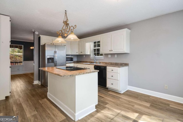 kitchen featuring a kitchen island, hanging light fixtures, black appliances, white cabinets, and light wood-type flooring