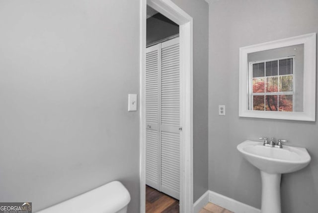 bathroom with toilet and hardwood / wood-style flooring