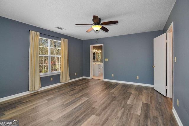 empty room with dark hardwood / wood-style flooring, ceiling fan, and a textured ceiling