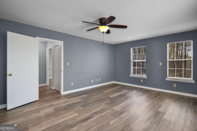 unfurnished room featuring wood-type flooring, a textured ceiling, and ceiling fan