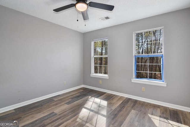 unfurnished room with ceiling fan, dark hardwood / wood-style floors, and a textured ceiling