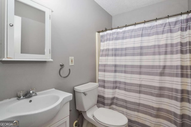 bathroom featuring toilet, vanity, and a textured ceiling