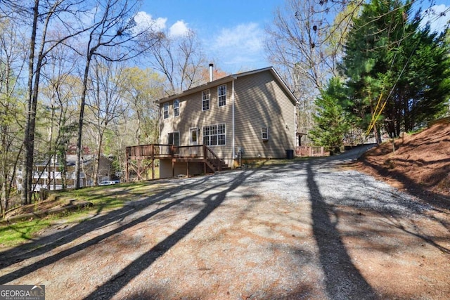 rear view of house featuring a wooden deck