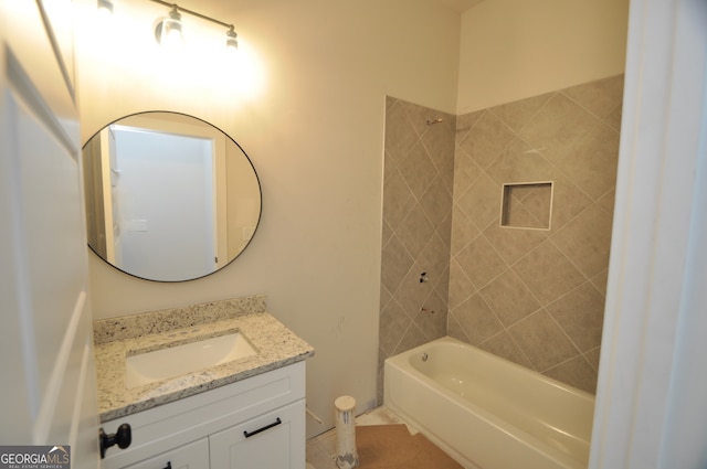 bathroom with tile patterned floors, vanity, and tiled shower / bath