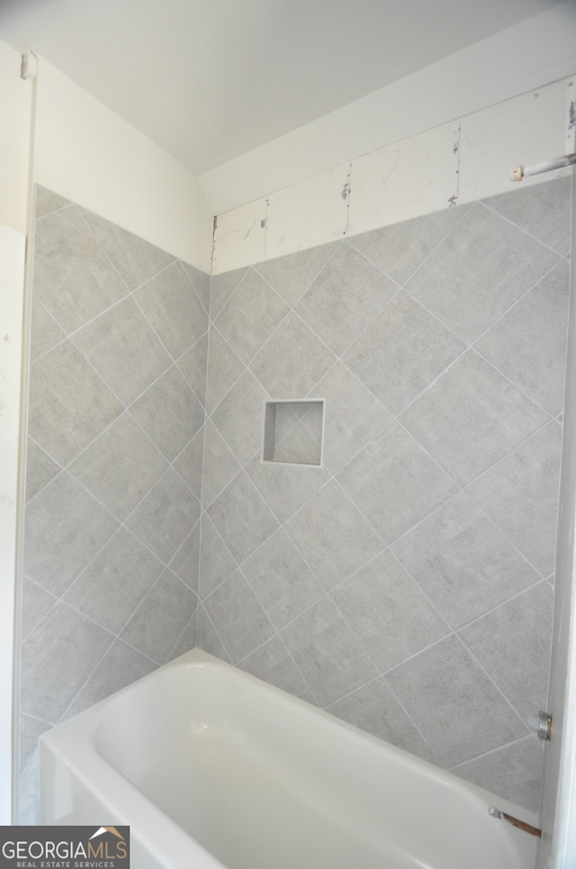 bathroom featuring tiled shower / bath