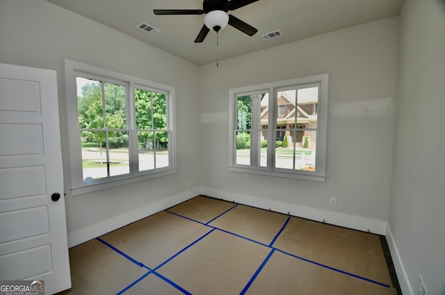 spare room featuring ceiling fan and plenty of natural light