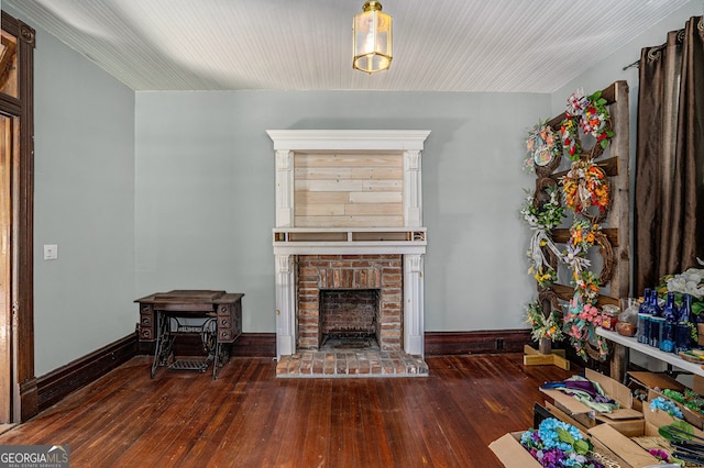 living room with dark hardwood / wood-style flooring and a brick fireplace