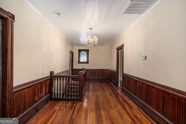 hallway with a chandelier, dark hardwood / wood-style flooring, and ornamental molding