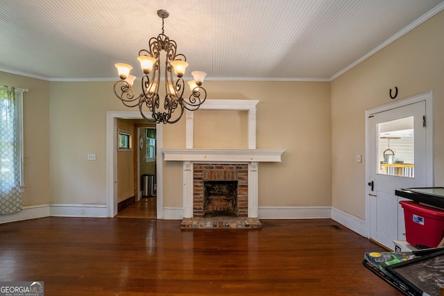 unfurnished living room featuring crown molding, an inviting chandelier, dark hardwood / wood-style floors, and a brick fireplace