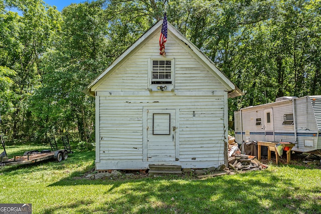 rear view of property with a lawn and a shed