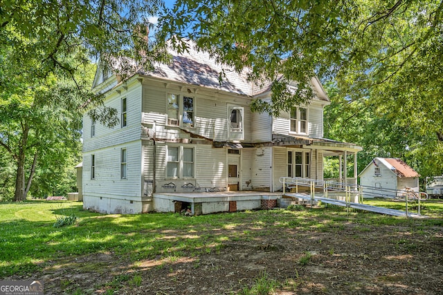 rear view of property with a lawn