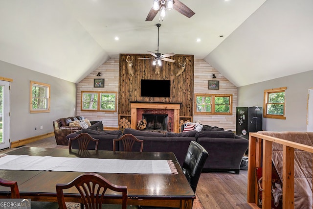 dining room with hardwood / wood-style floors, wooden walls, ceiling fan, and lofted ceiling