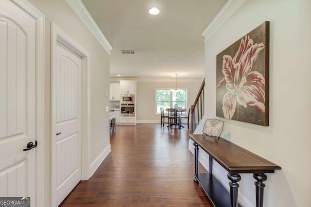 hallway with dark hardwood / wood-style floors and ornamental molding