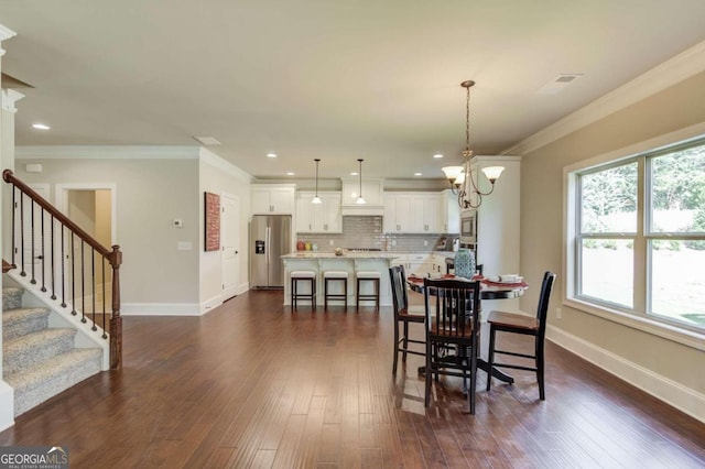 dining area with a notable chandelier, crown molding, and dark hardwood / wood-style floors