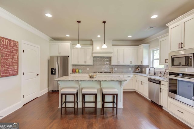 kitchen with decorative backsplash, a kitchen island, dark hardwood / wood-style flooring, hanging light fixtures, and stainless steel appliances