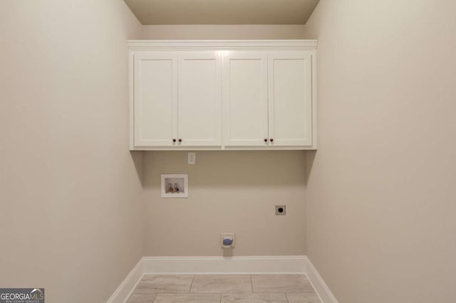 washroom with light tile patterned flooring, electric dryer hookup, washer hookup, and cabinets