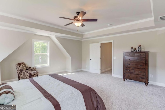 bedroom featuring ceiling fan, light colored carpet, and a tray ceiling