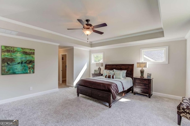 carpeted bedroom featuring ceiling fan, ornamental molding, and a tray ceiling