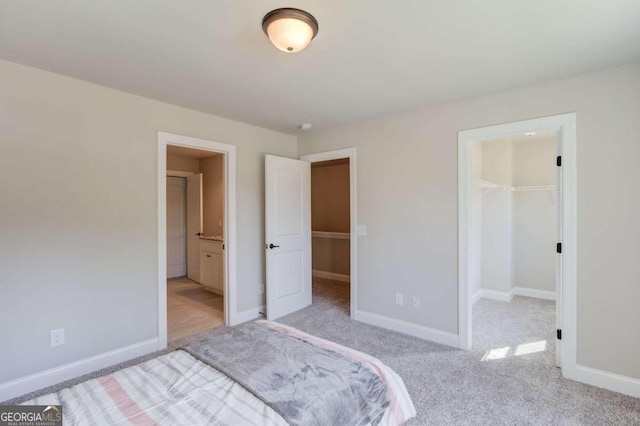 carpeted bedroom featuring a walk in closet and a closet