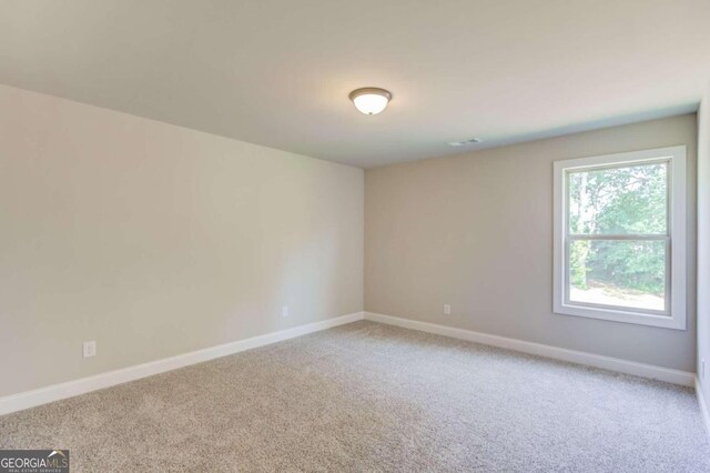 unfurnished room featuring light colored carpet