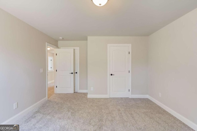 unfurnished bedroom featuring light carpet