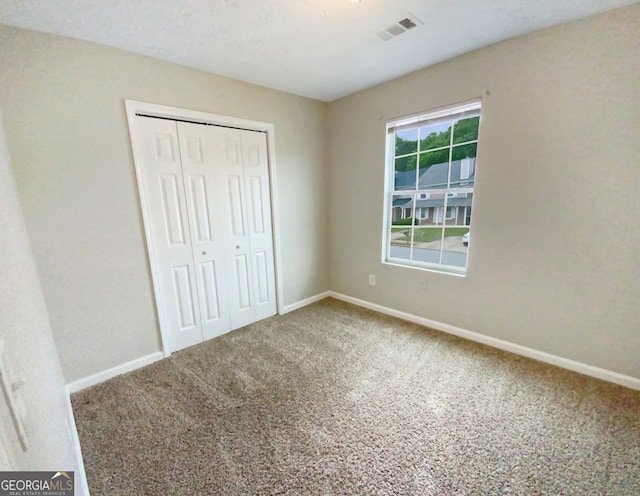 unfurnished bedroom with carpet flooring and a closet