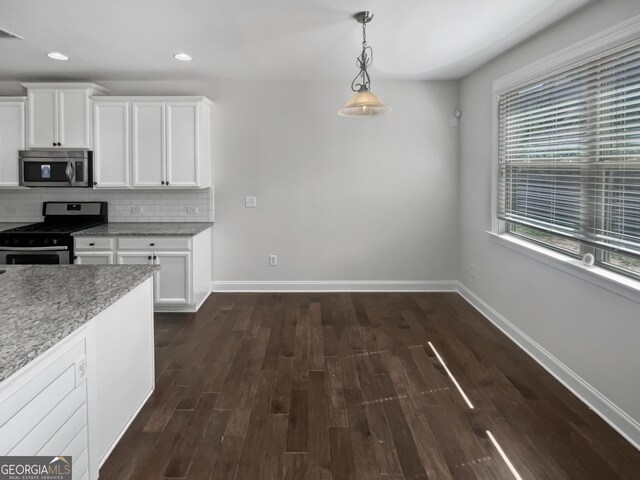 kitchen featuring decorative backsplash, light stone counters, stainless steel appliances, pendant lighting, and white cabinets