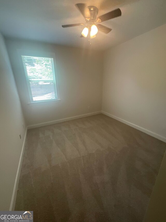 carpeted empty room featuring ceiling fan