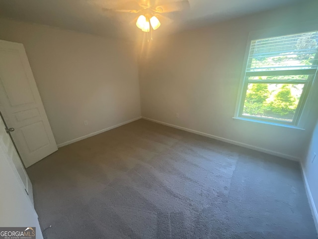 carpeted spare room featuring ceiling fan