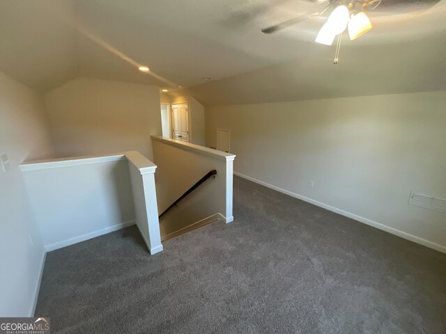 bonus room featuring ceiling fan, lofted ceiling, and dark colored carpet