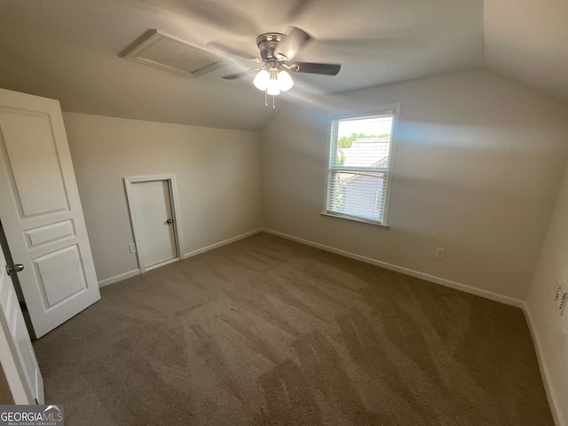 bonus room featuring dark carpet and vaulted ceiling