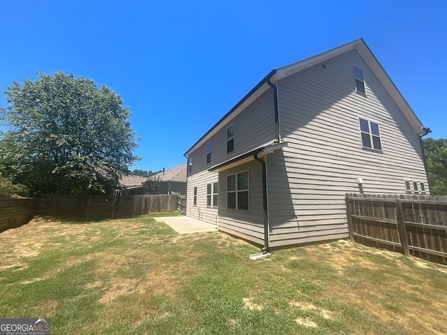 back of house featuring a lawn