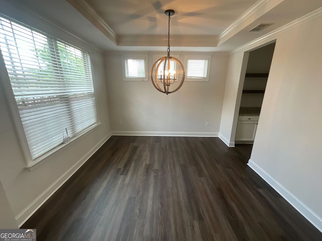 unfurnished dining area featuring dark hardwood / wood-style flooring, a raised ceiling, ornamental molding, and an inviting chandelier