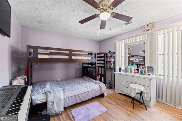 bedroom featuring multiple windows, ceiling fan, and light hardwood / wood-style flooring