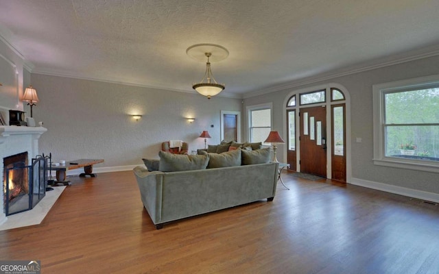 living room featuring a textured ceiling, hardwood / wood-style floors, and ornamental molding