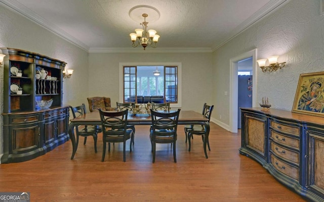 dining space with crown molding, a textured ceiling, a notable chandelier, and hardwood / wood-style floors