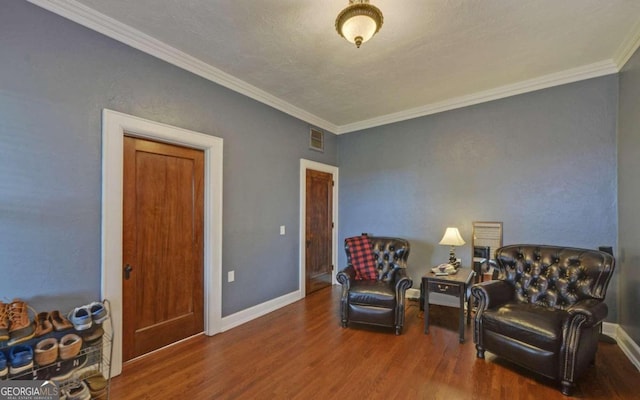 living area with wood-type flooring and ornamental molding