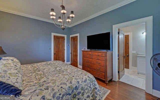 tiled bedroom featuring ornamental molding, an inviting chandelier, and ensuite bathroom