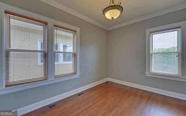 empty room with crown molding and hardwood / wood-style flooring