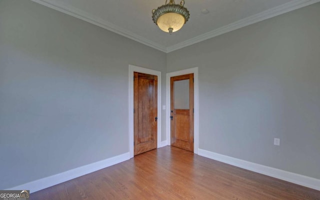 unfurnished room featuring ornamental molding and wood-type flooring