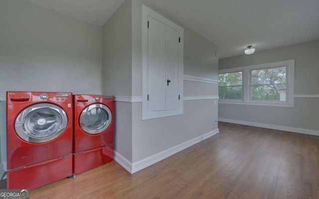 clothes washing area with washing machine and dryer and hardwood / wood-style flooring