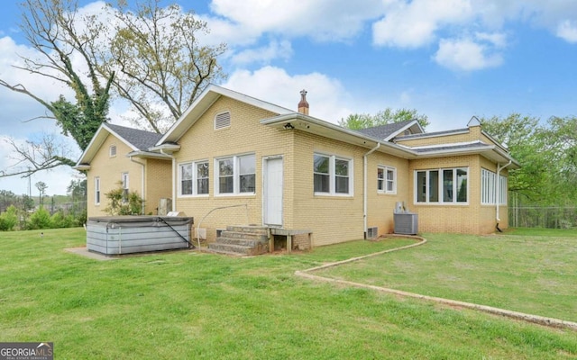 back of house with a yard and central air condition unit