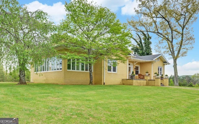 back of house with a patio and a lawn