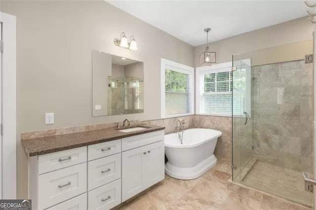 bathroom with tile walls, large vanity, tile floors, and separate shower and tub