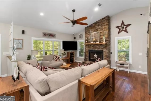 living room with a healthy amount of sunlight, dark wood-type flooring, ceiling fan, and a fireplace