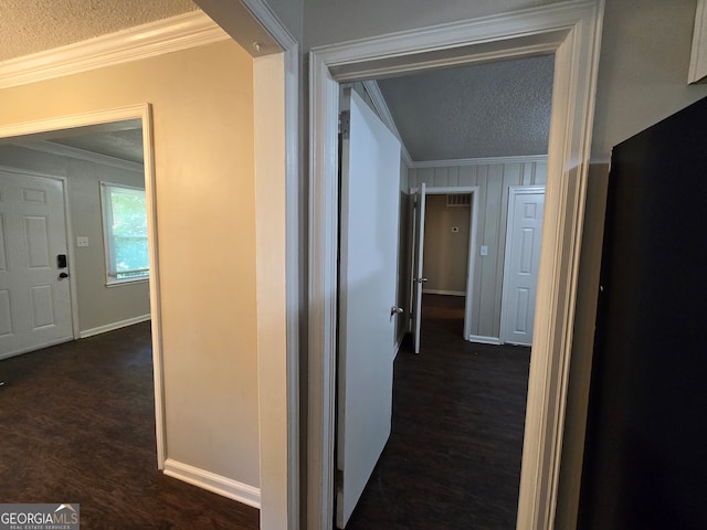 hallway with crown molding, dark hardwood / wood-style floors, and a textured ceiling